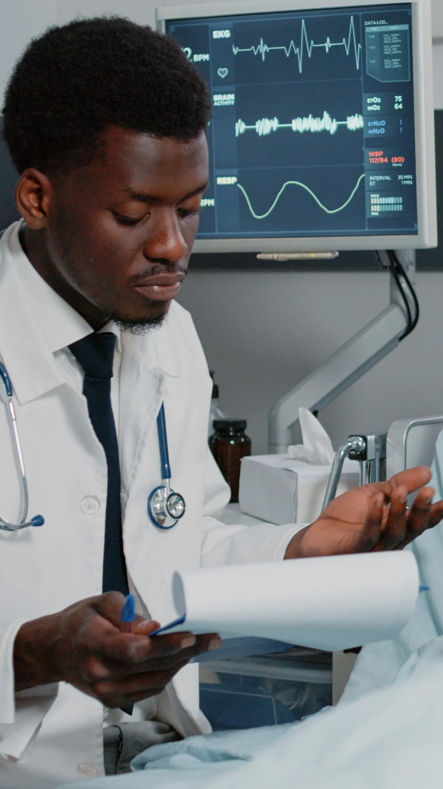 African american doctor consulting patient with IV drip bag. General practitioner checking examination files to treat person with disease, to cure with prescription treatment and medicine